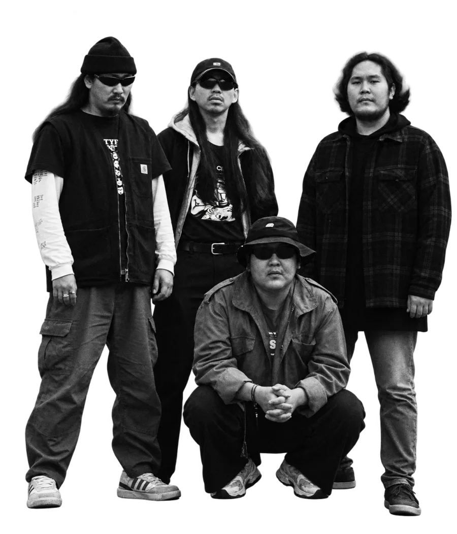KUTURAR in sunglasses, one member crouching in front